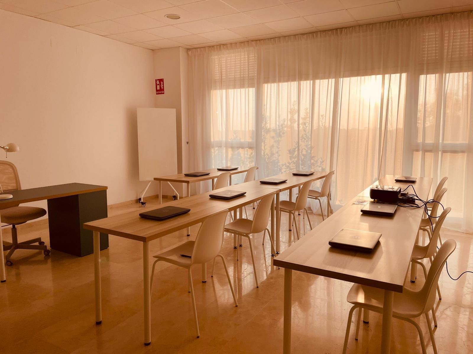 Aula de formación de Propuntos, con mesas, portátiles y luz natural